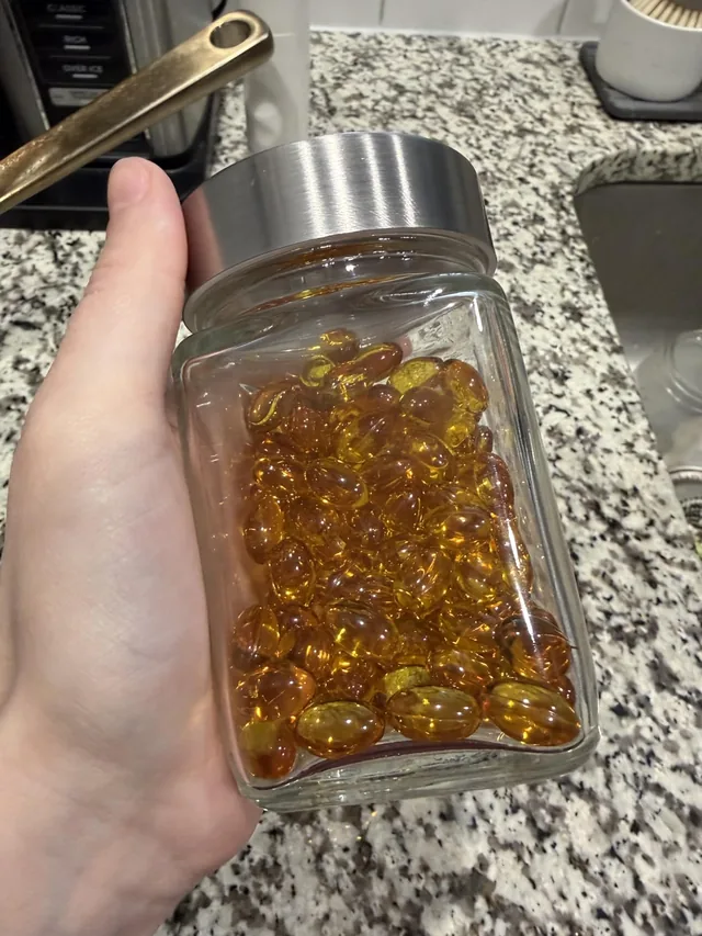 Frasco de cápsulas de aceite de orégano sobre la mesa de una clienta